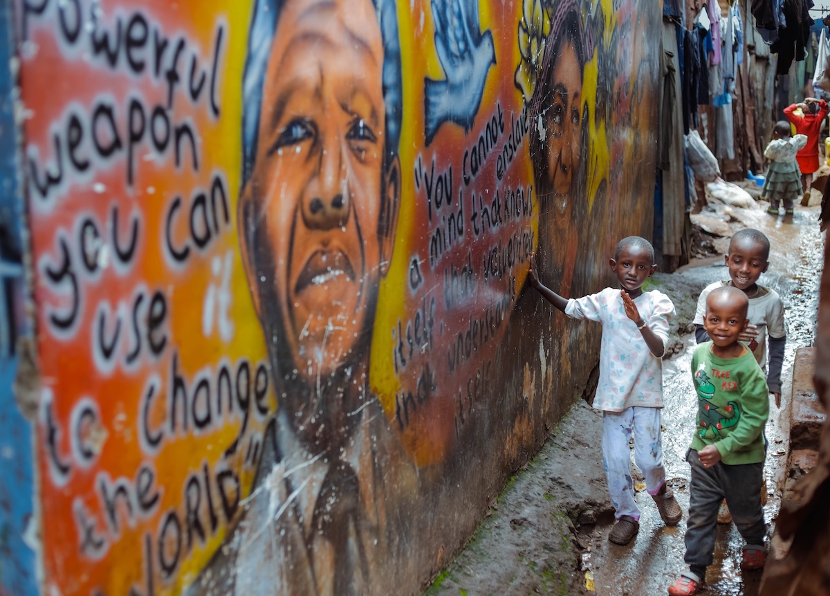 Children together beside a colourful mural