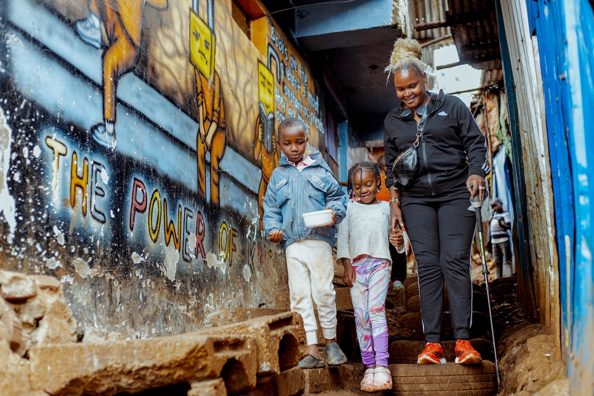An adult accompanying children along a neighbourhood path