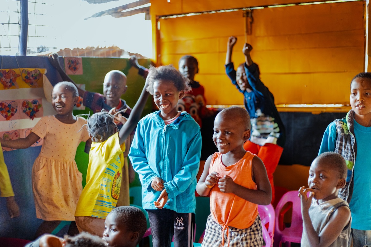 Children smiling and playing together in a colourful classroom