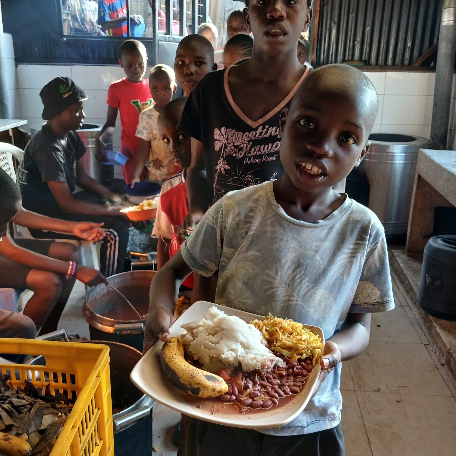 A child holding a nourishing meal from Palo’s Kitchen